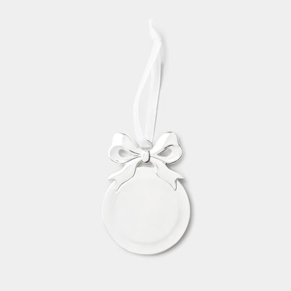 A minimalist silver oval Christmas ornament with a glossy finish, featuring a decorative white ribbon bow at the top